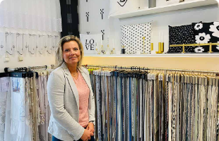 Frau steht vor aufgehängten Gradinenstoffen